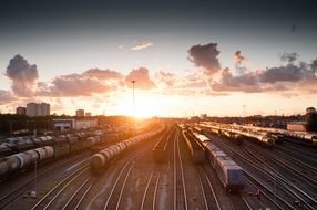 cargo trains on railway near station at sunset