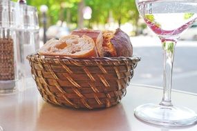 breadbasket with bread on table in open air restaurant