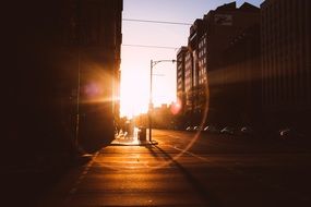 sunset flare above street in city