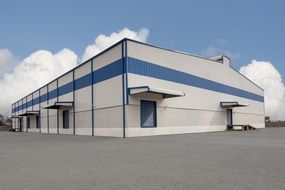 blue white industrial building construction sky clouds