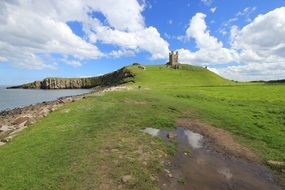 castle on a green hill near the sea