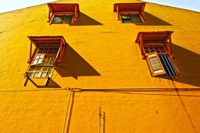 windows with shelters on orange facade