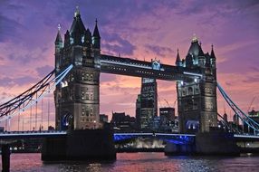 tower bridge across thames river at purple evening sky, uk, london