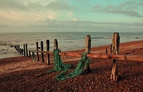 weathered wooden fence on seashore, uk, sussex, rye