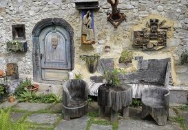 handmade wooden furniture at old ornamented stone wall