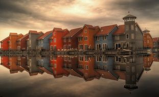 row of colorful houses with mirroring on water, netherlands, Reitdiephaven