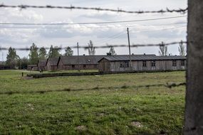 auschwitz-birkenau concentration camp behind barbed wire fence, poland