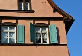 windows with open green shutters on facade of old house, germany, bamberg