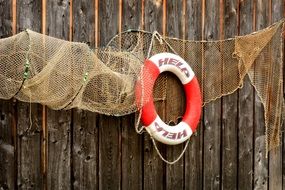 fishing net and lifebelt on a wooden wall