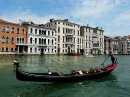 man with paddle in gondola on grand canal at june, italy, venice