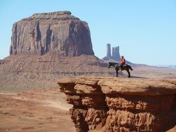 cowboy on black horse in monument valley, usa, utah