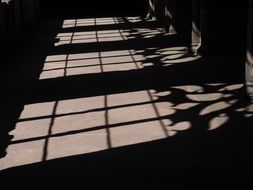 shadows from grates on stone floor