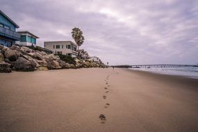 beach houses sand footprints rocks seashore