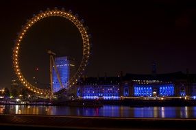 illuminated london eye ferris wheel and county hall at night, uk, england