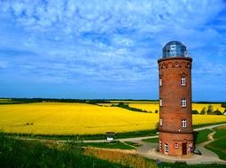 oldtime lighthouse tower at yellow field, landscape
