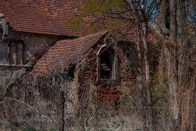 abandoned damaged stone building with red tiled roof