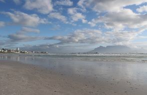 distant view of table mountain from beautiful ocean beach, south africa, cape town