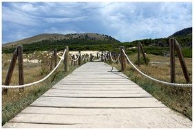 wooden rope fenced walk path through dunes in spain in mallorca