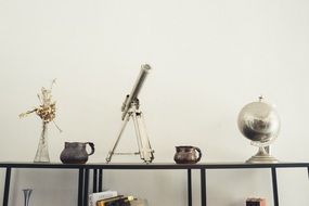 telescope, globe and vase on shelf, house deco