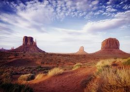 red desert with rock formations under cloudy sky, usa, utah, arizona, monument valley