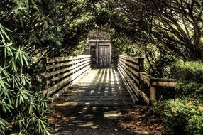 wooden bridge to entrance door in stone wall