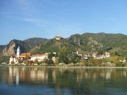 old town with church at danube river on mountain side, austria, wachau