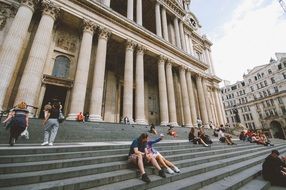 young people resting on stairs of old building