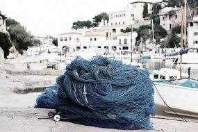 Blue fishing net in port white buildings aback