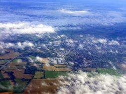aerial view of fields at countryside through clouds