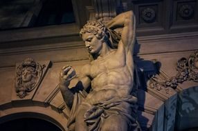 antique male sculpture on facade