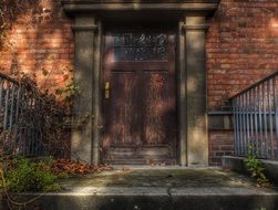 fenced stone porch at weathered wooden entrance door