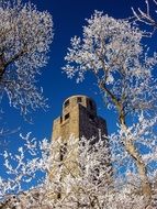 Kaiser tower at sky behind frosted trees, germany