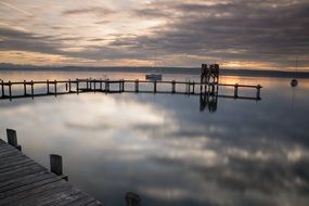 wooden pier on ammersee lake at sunset, germany, bavaria