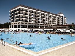 people in outdoor swimming pool at hotel, turkey, antalya