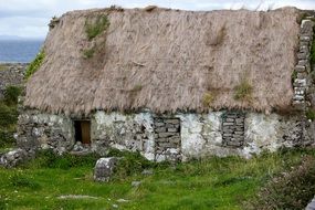 thatched roof of an abandoned stone hut in ireland