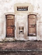 two old wooden closed doors on stone facade, italy, tuscany