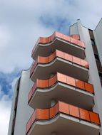 orange balconies on modern apartment facade