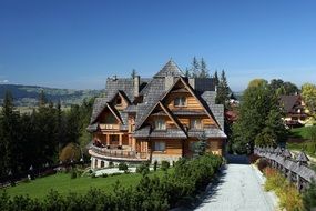 picturesque wooden house with shingle roof on hill side, poland