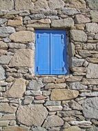 blue window on a stone wall