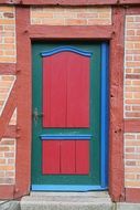 red brick wall colored wood door