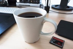 coffee cup and memory card on desk