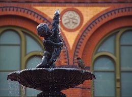 small bird sits on antique fountain