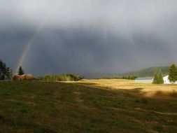 rainbow in the dark sky over british columbia