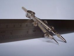 compass on metal ruler, drawing tools