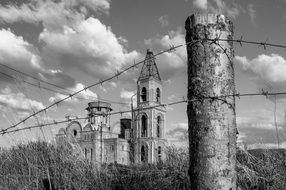 ruined church behind barb wire fence, russia, siberia