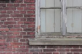 closed window red brick wall