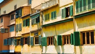 green shutters on yellow facade at sunny day