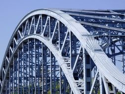 arched metal fence of bridge at sky