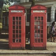 two vintage red telephone box on street, uk, england, london