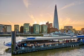 ship at pier in view of the shard building in city skyline, uk, england, london